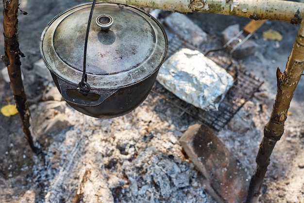 Boiling pot at the campfire on picnic. Hike cooking concept