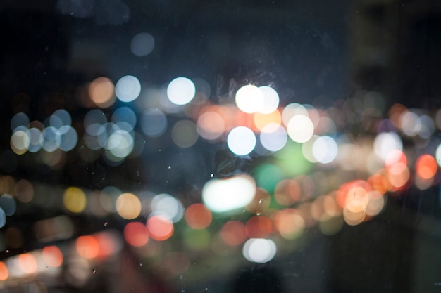 Bokeh lights on the rain look out the window .