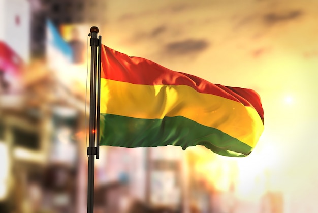 Bolivia Flag Against City Blurred Background At Sunrise Backlight