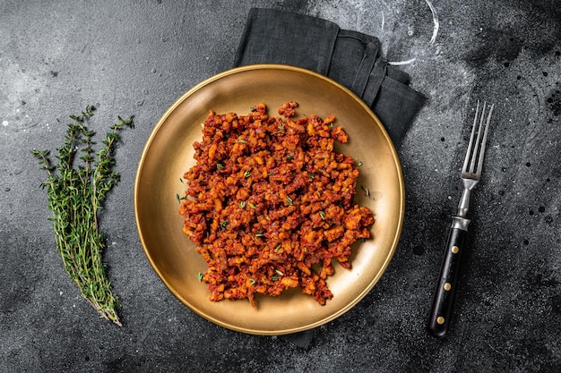 Bolognese sauce with ground beef stewed with tomato sauce and spices Black background Top view