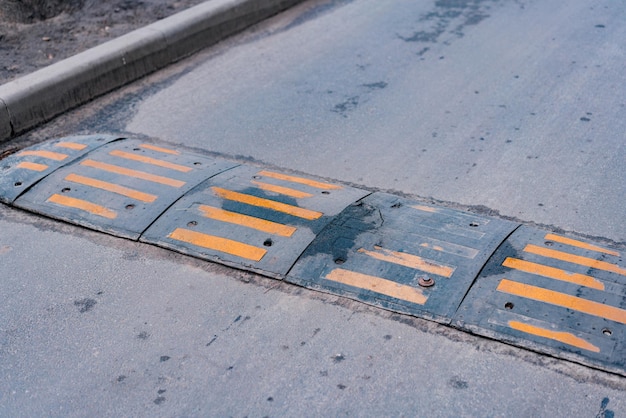 Bolted down speed bump line made of rubber on asphalt road Sleeping policemen Street Low speed Slow down