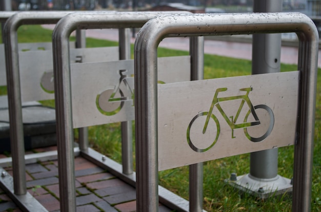 Bolted to pavement vertical metal arcs for bike parking green grass sidewalk behind