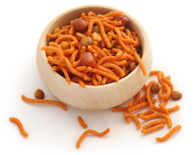 Bombay mix in a wooden bowl over white background