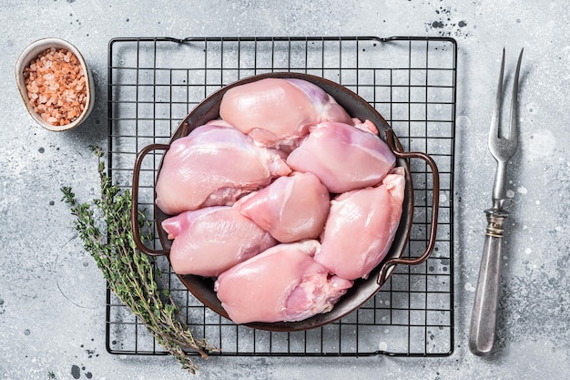 Boneless and skinless Raw Chicken leg thigh fillet Gray background Top view