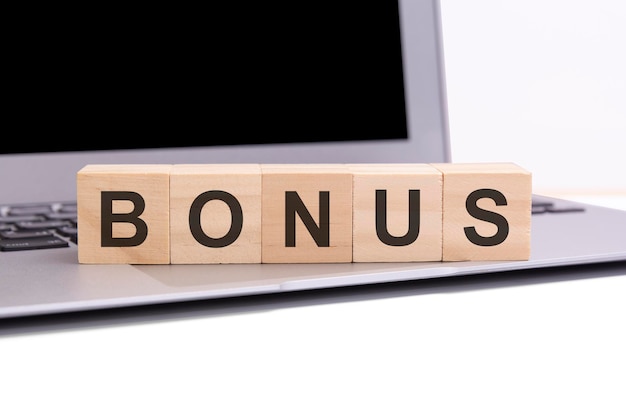 Bonus - wooden cubes with letters on a silver laptop keyboard