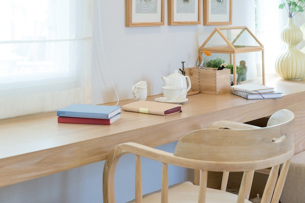 Book and coffee cup and jar on wooden table with decoration in home.