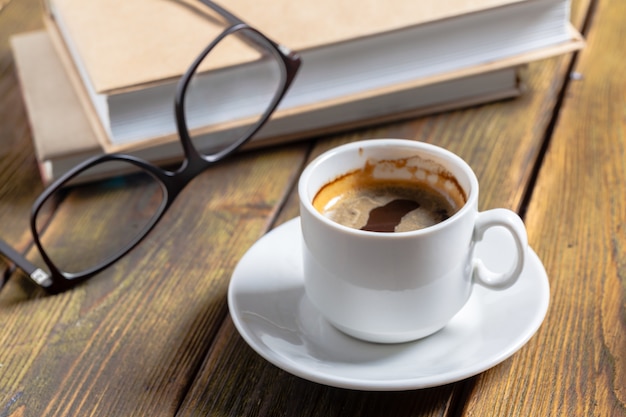 book and a cup of coffee on wooden background