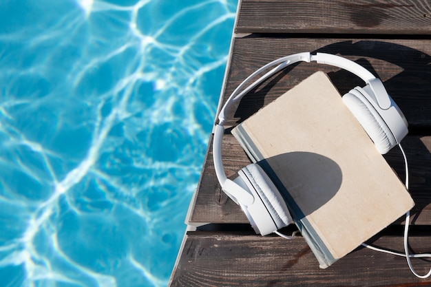 Photo book and headphones near swimming pool