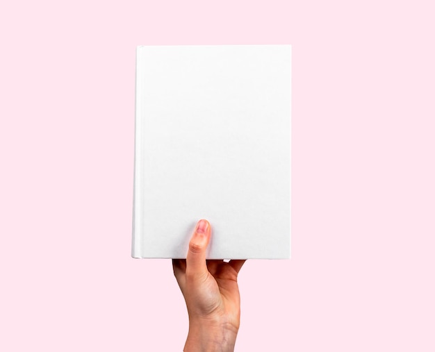 Book mockup in hand on pink Paper literature mock up empty white hard cover template