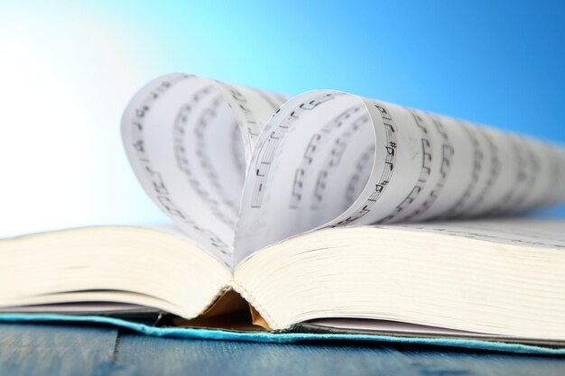 Book pages curved into heart shape on blue background