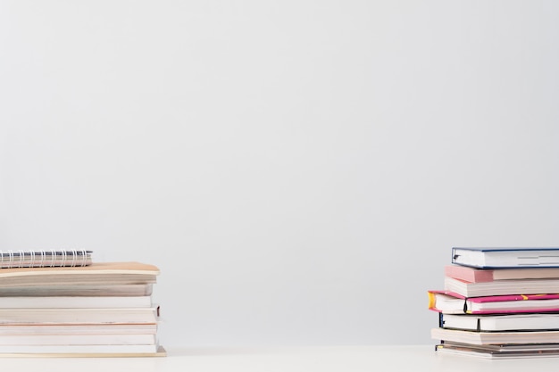 Book stacks on desk over white.