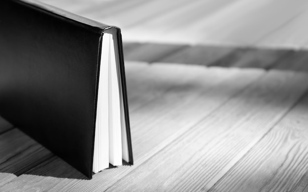 Book with blank cover on wooden table