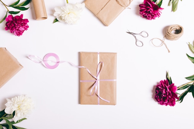 Book in wrapping paper with ribbon lies on a white table