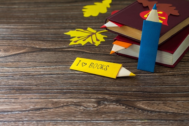 Bookmarks origami pencil made of paper with the inscription that I love a book  Copy space