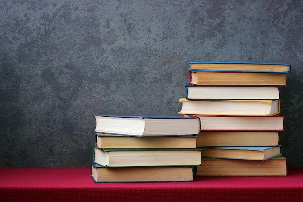 Books with colored covers on the table with a red tablecloth 