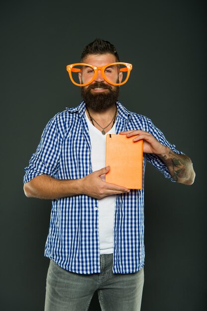 Bookworm. Book nerd wearing fancy glasses. Study nerd holding book. University male student with lecture notes. Bearded man in party glasses with lesson book.