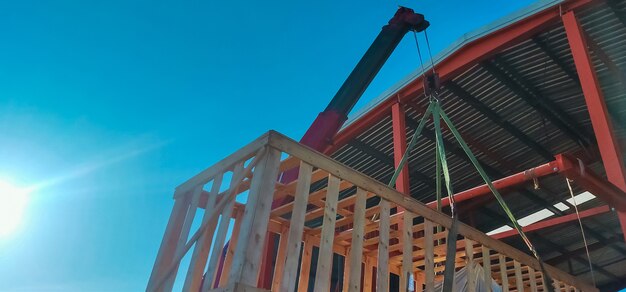 Boom truck crane lifting the machinery which storage in wooden box to stored in warehouse