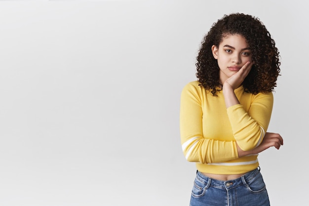 Bored careless indifferent young moody girl have no interest family event standing reluctant annoyed facepalming lean face hand look camera ignorant standing white background sad