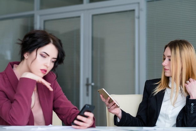 Bored indifferent business women on board meeting waiting for boss idlers at work killing time