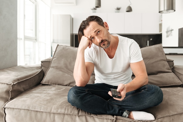 Bored mature man sitting on a sofa