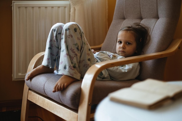 Bored upset little girl in the room moody alone