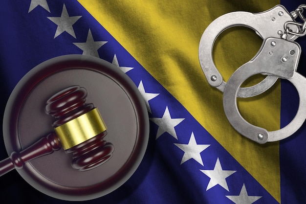 Bosnia and Herzegovina flag with judge mallet and handcuffs in dark room Concept of criminal and punishment background for judgement topics