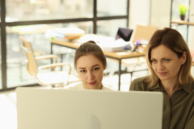 Boss and manager are looking at computer display in office two managers working together at