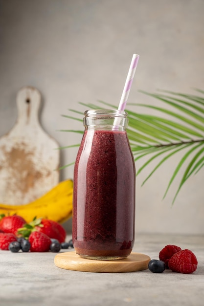 Bottle of berry smoothie in a glass Strawberry banana blueberry healthy drink Copy space