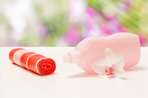 Bottle of dishwashing liquid garbge bags on blurred background