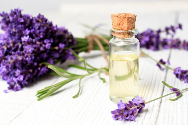 A bottle of essential oil and a bouquet of fresh lavender flowers spa treatments and aromatherapy