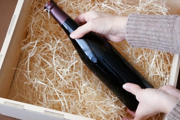 bottle of expensive elite wine in a wooden box with shavings