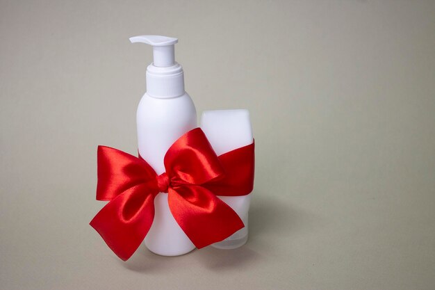 A bottle of hand soap with a red ribbon tied around it.