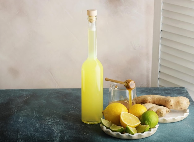 Bottle of homemade juice with ginger and lemon on light background Horizontal