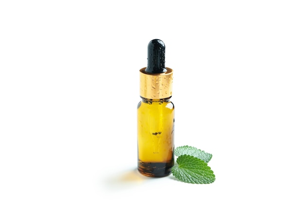 Bottle of liquid and mint isolated on white background