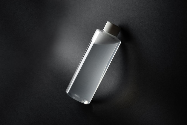 Bottle of micellar water tonic on a black background template