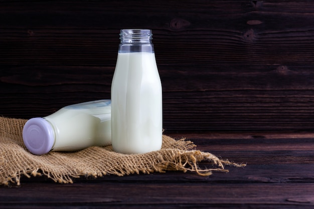 Bottle of milk on wooden background.