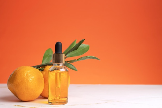 Bottle of orange essential oil for aromatherapy Orange essential oil Citrus essential oil on friut background with copy space