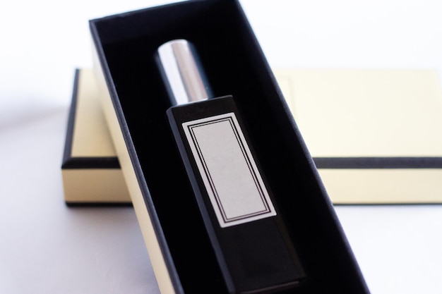 A bottle of perfume from a yellow box on a white isolated background