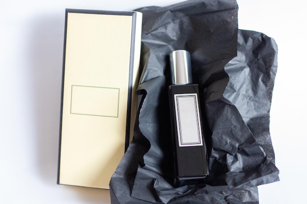 A bottle of perfume from a yellow box on a white isolated background