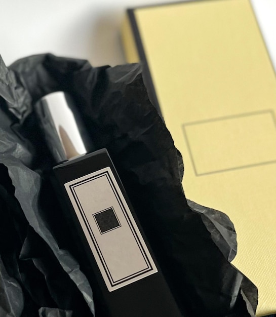 A bottle of perfume from a yellow box on a white isolated background