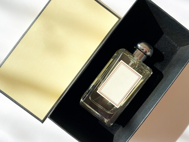 A bottle of perfume from a yellow box on a white isolated background