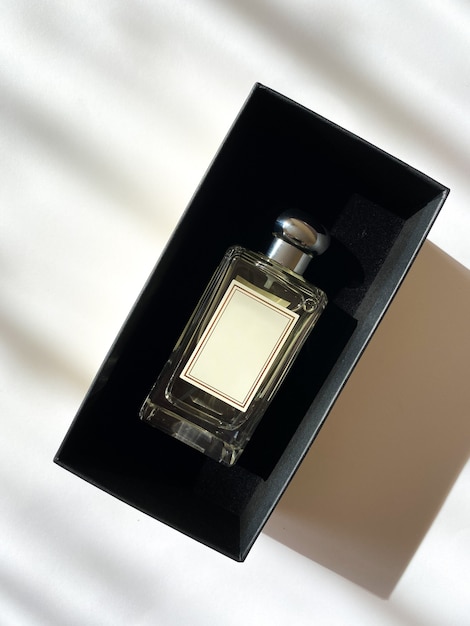 A bottle of perfume from a yellow box on a white isolated background