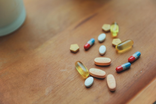 A bottle of pills on a table with a white bowl of pills on it.