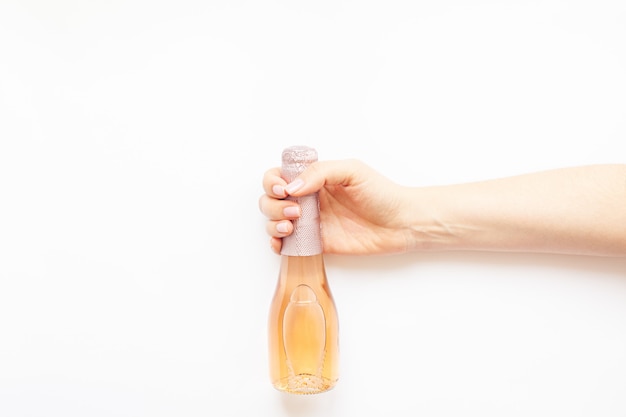 Bottle of rose champagne wine in woman hand