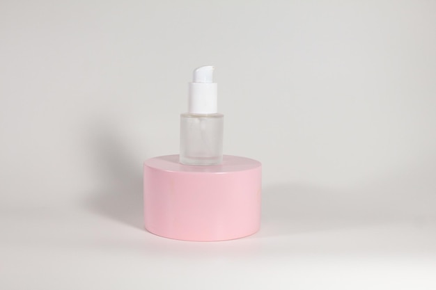 A Bottle of Skincare with Pink Podium and White Background