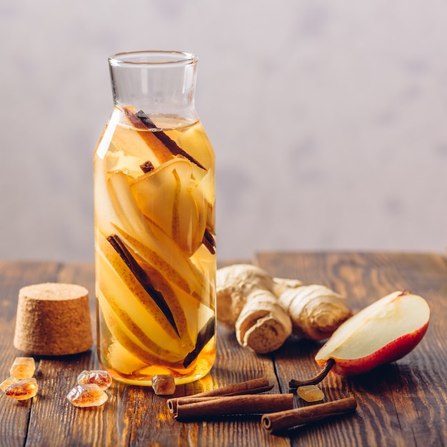 Bottle of Water Infused with Sliced Pear, Cinnamon Stick, Ginger Root and Dark Sugar