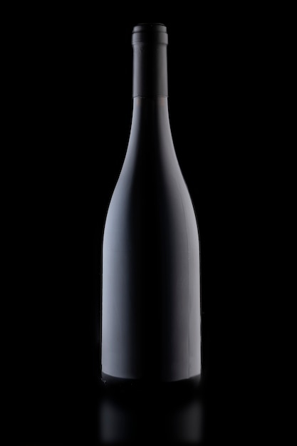 A bottle of wine on a black background, close-up vertical photo.