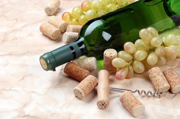 Bottle of wine grapes and corks on old paper background