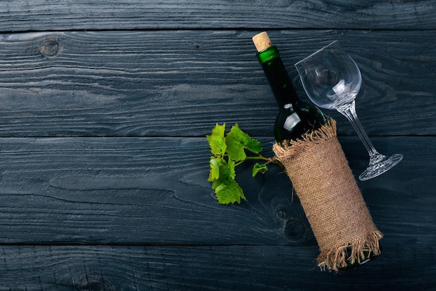 A bottle of wine and grapes On a wooden background Top view Free space for your text