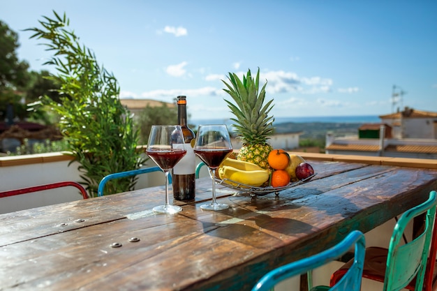 Bottle of wine with two glasses and a plate of exotic fruits